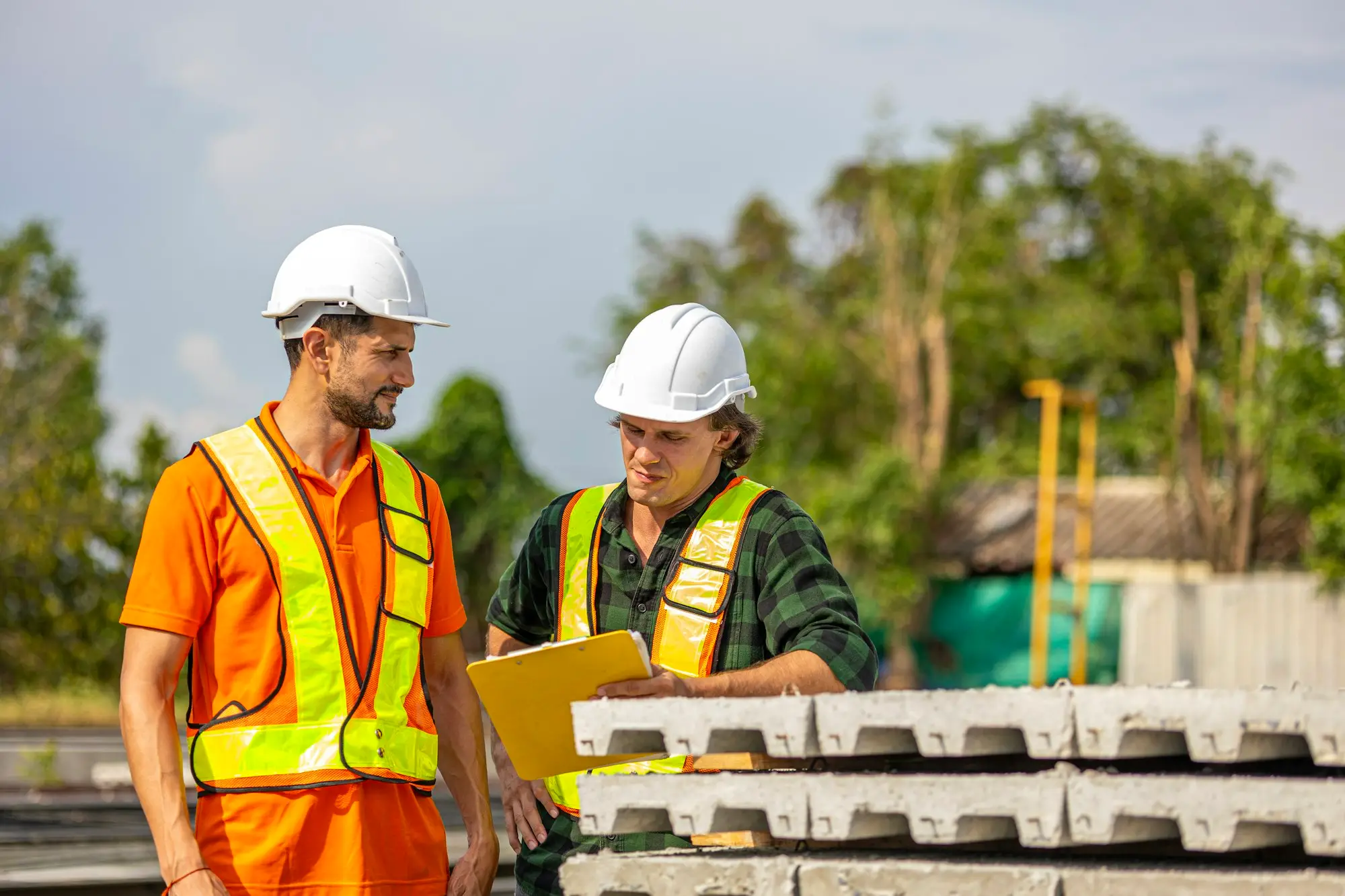 Two workers in hi-vis reviewing plans on site